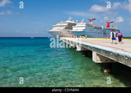 Kreuzfahrtschiffen Sie Passagiere von auf Pier Aussteigen aus Karneval Kreuzfahrt-Schiffe, Triumph und Ekstase in Cozumel, Mexiko Stockfoto