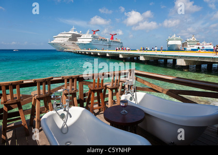 Outdoor-Badewannen auf Holzterrasse mit Blick auf Kreuzfahrt Schiff Hafen in drei Amigos Cantina in Cozumel, Mexiko im karibischen Meer Stockfoto