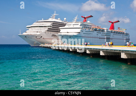 Kreuzfahrtschiffen Sie Passagiere von auf Pier Aussteigen aus Karneval Kreuzfahrt-Schiffe, Triumph und Ekstase in Cozumel, Mexiko Stockfoto