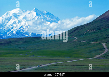 Ein Auto folgt eine einsame Straße in Richtung Norden Amerikas höchstem Berg, 20,310-foot Denali (Mount McKinley), in Denali National Park, Alaska, USA. Stockfoto