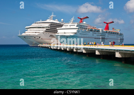 Kreuzfahrtschiffen Sie Passagiere von auf Pier Aussteigen aus Karneval Kreuzfahrt-Schiffe, Triumph und Ekstase in Cozumel, Mexiko Stockfoto