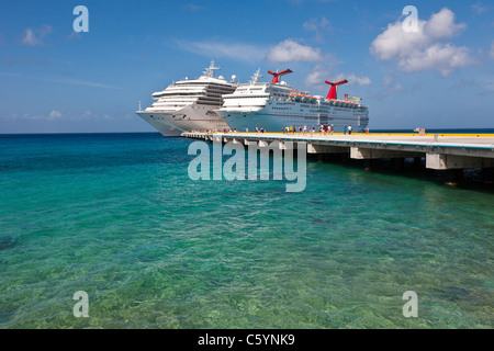 Kreuzfahrtschiffen Sie Passagiere von auf Pier Aussteigen aus Karneval Kreuzfahrt-Schiffe, Triumph und Ekstase in Cozumel, Mexiko Stockfoto