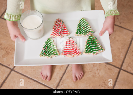 USA, Illinois, Metamora, Mädchen (6-7) Holding Tablett mit Weihnachtsgebäck und Glas Milch Stockfoto