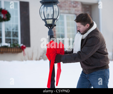 USA, Illinois, Metamora Mitte erwachsenen Mannes Dekoration Laterne vor Haus mit Weihnachten ribbon Stockfoto