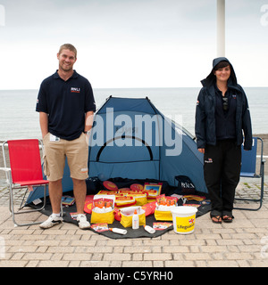 zwei RNLI Arbeiter verkaufen Markenartikel um Geld für wohltätige Zwecke, Aberystwyth Wales UK Stockfoto