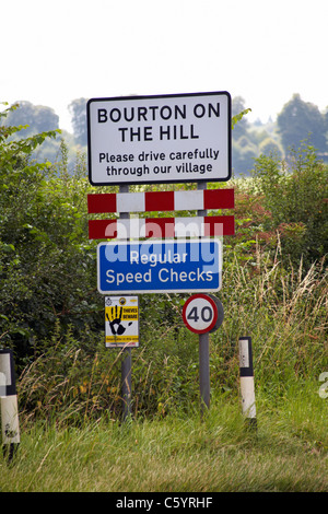 Bourton on the Hill fahren Sie bitte vorsichtig durch unser Dorf und regelmäßige Geschwindigkeitskontrollen-Schilder in den Cotswolds, Gloucestershire, Großbritannien im Juli Stockfoto
