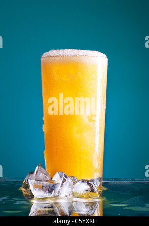 Glas orange Soda mit Eis auf blauem Hintergrund Stockfoto