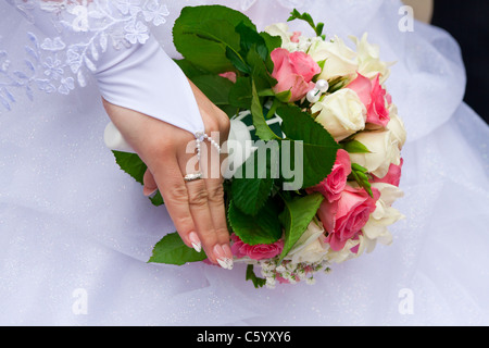 Braut die Hand mit dem Ring am Finger hält das Bukett Stockfoto