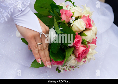 Braut die Hand mit dem Ring am Finger hält das Bukett Stockfoto