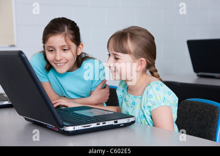 USA, Illinois, Metamora, zwei Mädchen auf der Suche am Laptop (8-9, 10-11) im Computerraum