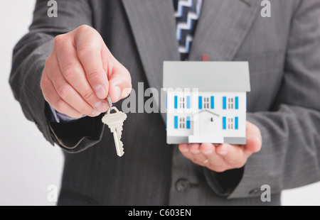 Nahaufnahme eines Mannes Hände halten Musterhaus und Schlüssel Stockfoto