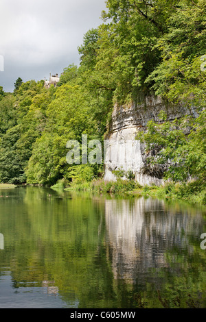 Der Mühlenteich am Fluss Wye am Cressbrook Dale in Derbyshire White Peak mit Cressbrook Halle hoch über dem Tal Stockfoto