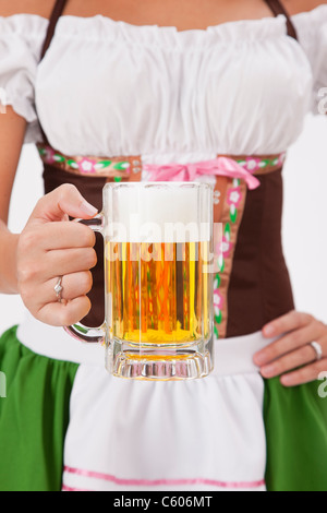 Junge Frau trägt Oktoberfest Kostüm mit Bierkrug, Studio gedreht Stockfoto