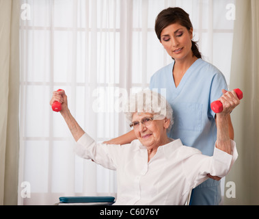 USA, Illinois, Metamora, Krankenschwester, die Unterstützung der älteren Frau mit Hanteln Stockfoto