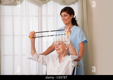 USA, Illinois, Metamora, Krankenschwester, die Unterstützung von senior Frau im Rollstuhl mit Übungsband Stockfoto