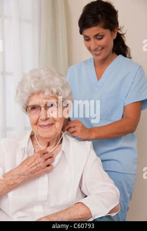 USA, Illinois, Metamora, Krankenschwester helfen senior Frau, Perlenkette setzen Stockfoto