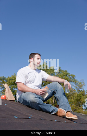 USA, Illinois, Metamora, junger Mann auf dem Dach sitzen und Essen Stockfoto