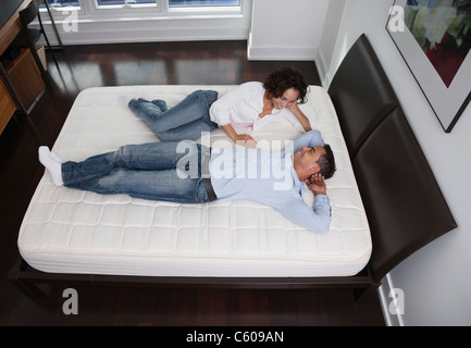 USA, New York State, New York City, junges Paar auf Bett liegend Stockfoto