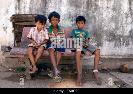 Junge Street Kind jungen in Armut leben, die Müll für Wertstoffe suchen sitzen auf einer Bank in Kambodscha. Stockfoto