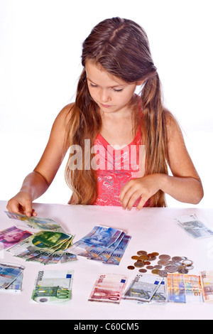 acht Jahre altes Mädchen zählt ihr Geld Stockfoto