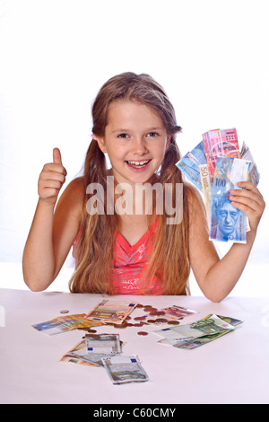 acht Jahre altes Mädchen zählt ihr Geld Stockfoto