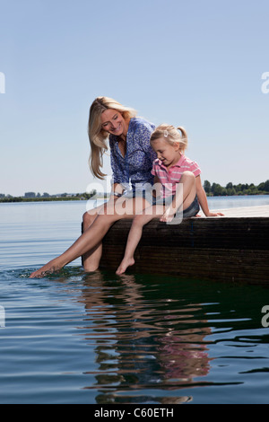 Mutter und Tochter entspannend auf dock Stockfoto