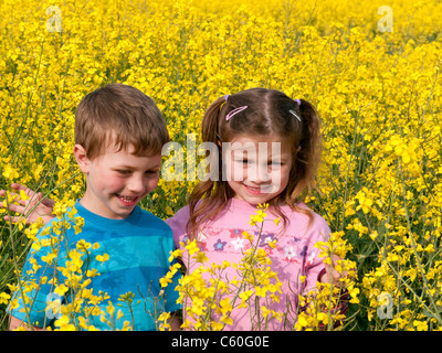 Jungen und Mädchen in einem Feld von gelben Raps im Frühjahr in Chesham, Bucks, Großbritannien Stockfoto