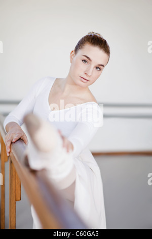 Ballett-Tänzerin stretching am barre Stockfoto