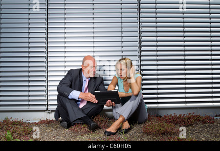 Business-Leute sitzen in Rasen Stockfoto