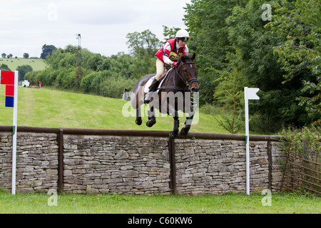 Pferd und Reiter Löschen einer Wand auf der Langlaufloipe auf dem britischen Festival der Vielseitigkeit in Gatcombe Park in Gloucestershire Stockfoto