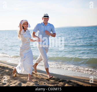 Brautpaar am Strand laufen Stockfoto