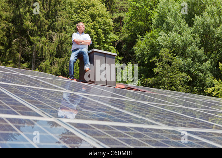 Mann auf getäfelten Solardach Stockfoto