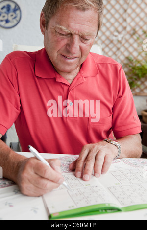 Ältere Mann abschließen Sudoku-Rätsel Stockfoto