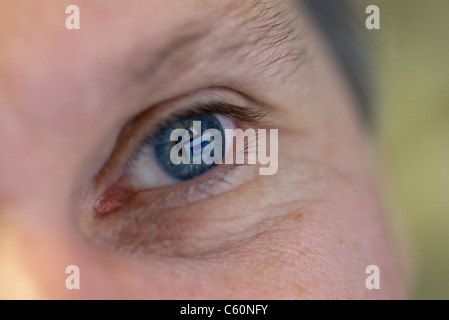 Nahaufnahme eines Mannes blaues linkes Auge mit Facebook spiegeln sich darin Stockfoto