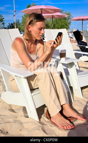Junge Frau SMS, Sugar Beach, Toronto, Ontario, Kanada Stockfoto