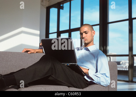Geschäftsmann mit Laptop auf couch Stockfoto