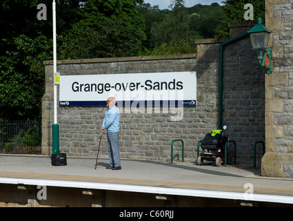 Ältere Menschen warten auf einen Zug am Bahnhof Grange-über-Sande, South Lakeland, Cumbria, England UK Stockfoto