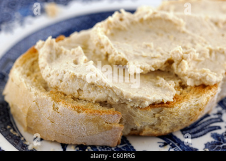 Dick hausgemachter Hummus mit zusätzlichen Garlick verteilt auf frisch geröstetem Weißbrot Stockfoto