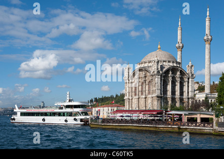 Ortakoy-Moschee (auch bekannt als der Mecidiye-Moschee) und ein Tourenboot am Ufer des Bosporus in Istanbul Stockfoto