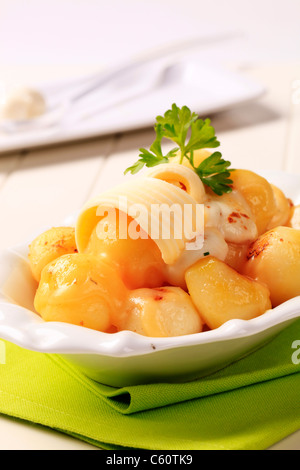 Schüssel mit Kartoffeln garniert mit geschmolzenem Käse und butter Stockfoto