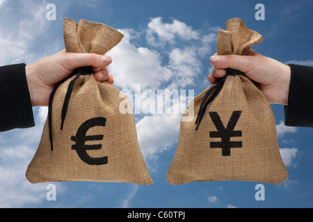 ein Geldbeutel mit Euro-Zeichen und ein Geldbeutel mit Yen-Zeichen sind Hand-Held Stockfoto