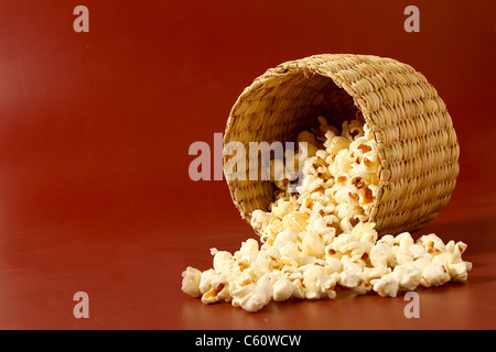 verbreiten Sie Popcorn auf rotem Grund mit Korb Stockfoto