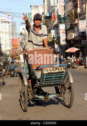 Dreirad-Rikscha-Fahrer ruft nach einem Fahrpreis in Ho Chi Min Stadt, Vietnam Stockfoto