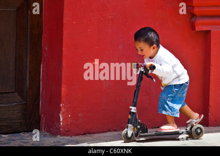 Kleiner Junge spielt mit einem Rasiermesser Roller, Antigua, Guatemala Stockfoto