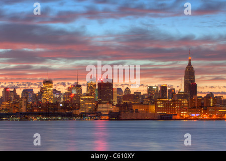 Der Himmel beginnt zu erleichtern und Wolken reflektieren vor Sonnenaufgang Farbe über das Empire State Building und die Skyline von Midtown Manhattan Stockfoto