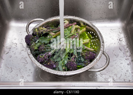 Waschen Gemüse in einem Edelstahl-Sieb. Stockfoto