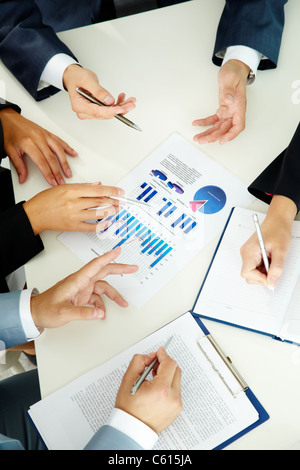 Bild von Menschenhand mit Stiften über geschäftliche Dokumente der Tagung Stockfoto