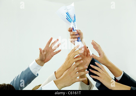 Bild von mehreren menschlichen Händen versucht, Papier von männlichen Hand bekommen Stockfoto