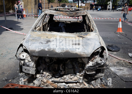 Ein Auto sitzt völlig verbrannten im Zentrum von Woolwich, Süd-Ost-London, nach einer Nacht mit Krawallen und Plünderungen. Stockfoto