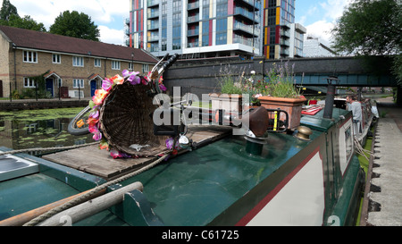 Schmalboot, Gartentopf auf Schmalboot Dach, Fahrrad und neue Wohnung Gebäude entlang Lea Valley Walk towpath in East London, England Großbritannien KATHY DEWITT Stockfoto